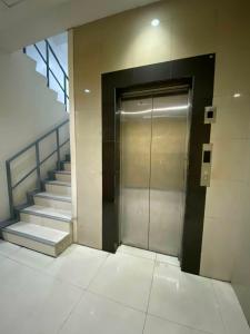 a metal elevator in a building with stairs at Nice Hotel Arayat Cubao in Manila