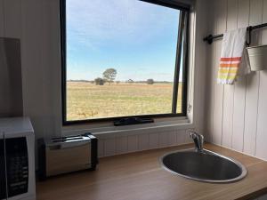 a sink in a kitchen with a large window at Loft Tiny House by Tiny Away in Banyena