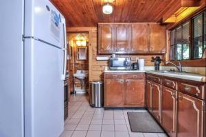 a kitchen with wooden cabinets and a white refrigerator at Pine Haven in Mercer