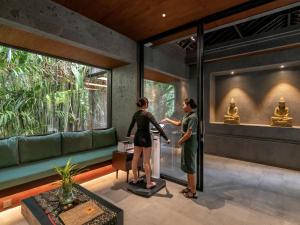 two women standing in a room looking at a window at Gdas Bali Health and Wellness Resort in Ubud