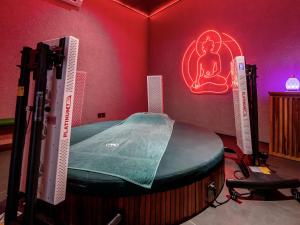 a room with a bed in a room with a neon sign at Gdas Bali Health and Wellness Resort in Ubud