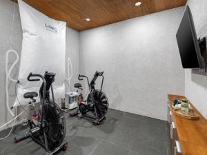 two bikes are parked in a room with a wall at Gdas Bali Health and Wellness Resort in Ubud