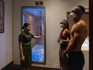a man and two women wearing masks in front of a window at Gdas Bali Health and Wellness Resort in Ubud