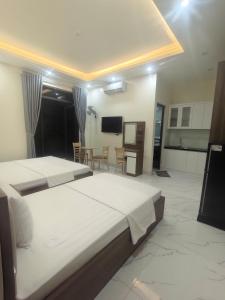 a bedroom with a large bed and a dining room at Hotel Xanh Fly in Nhật Tựu