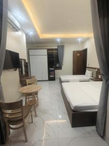 a hotel room with two beds and a table at Hotel Xanh Fly in Nhật Tựu