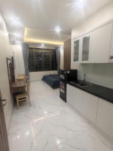 a kitchen and living room with a bed in the background at Hotel Xanh Fly in Nhật Tựu