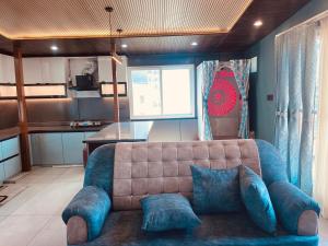 a living room with a couch and a kitchen at Soar Serenity Homes in Pithorāgarh