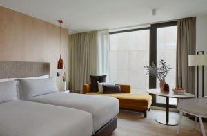 a hotel room with a bed and a chair and a table at ME by Meliá Barcelona in Barcelona