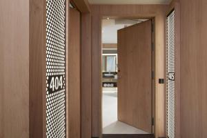 a hallway with a wooden door and a mirror at ME by Meliá Barcelona in Barcelona