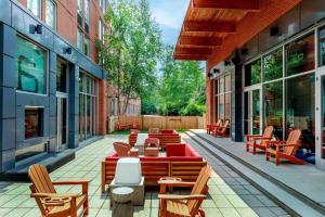 a patio with chairs and tables on a building at Aloft by Marriott Lexington in Lexington