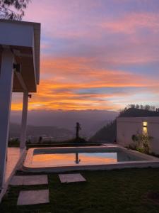a sunset view of a house with a swimming pool at Rumah pinggan private pool in Kubupenlokan