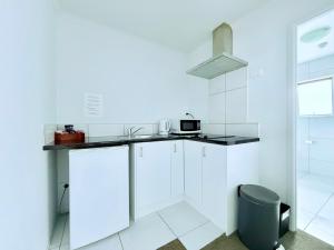 a white kitchen with a counter and a sink at BKs Premier Motel Hamilton in Hamilton