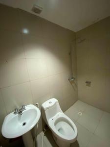a white bathroom with a sink and a toilet at Nice Hotel Arayat Cubao in Manila