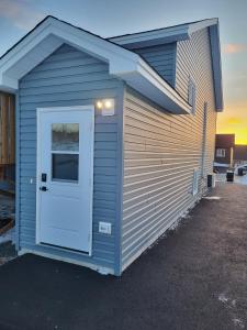 a garage with a white door on the side of a building at Lovely Two-Bedroom APT at Kenmount Terrace in St. John's