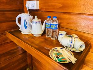 a shelf with plates and bottles of water on it at Chaya Villa Sigiriya in Sigiriya