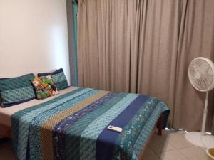 a bedroom with a bed with a blanket and a fan at Lucky get away in Poughkeepsie