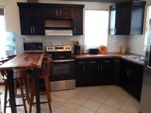 a kitchen with black cabinets and a wooden table at Lucky get away in Poughkeepsie