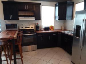 a kitchen with black cabinets and a wooden counter top at Lucky get away in Poughkeepsie