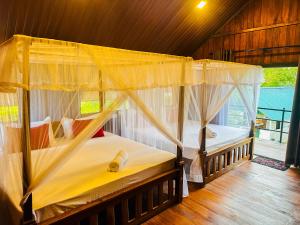 a bedroom with two beds with mosquito nets at Chaya Villa Sigiriya in Sigiriya