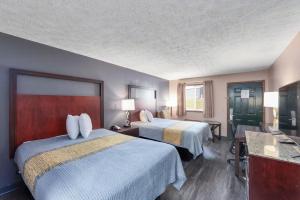 a hotel room with two beds and a television at Colonial Inn Camden in Camden