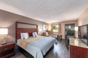 a hotel room with a bed and a television at Colonial Inn Camden in Camden