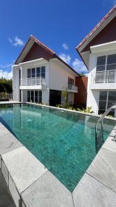a swimming pool in front of a house at Rdm Bali Guest House in Badung