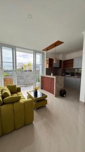 a living room with a yellow couch and a kitchen at Rdm Bali Guest House in Badung