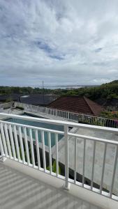 a balcony with a white railing and a view of the ocean at Rdm Bali Guest House in Badung
