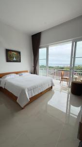 a bedroom with a large bed and a balcony at Rdm Bali Guest House in Badung +23 photos