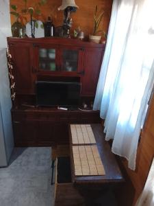 a wooden cabinet with a television in a room at Gather in Balneario Argentino
