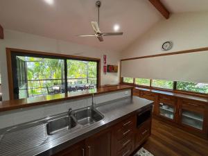 a kitchen with a sink and a large window at Amaroo - Bring your own linen in Arakoon +13 photos