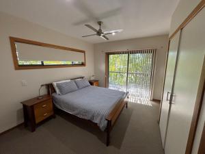 a bedroom with a bed and a window and a door at Amaroo - Bring your own linen in Arakoon