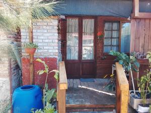 a house with a wooden door and some plants at Gather in Balneario Argentino