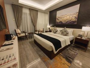 ein Hotelzimmer mit einem großen Bett und einem Stuhl in der Unterkunft Madayaw Hotel Tagum in Tagum + 73 Fotos