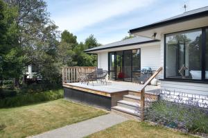 a house with a deck with a patio at Brookside Villa - Christchurch Holiday Homes in Christchurch