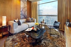 a living room with a couch and a large window at Ascott Orchard Singapore in Singapore
