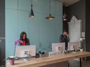 a man and a woman standing in front of a mirror at Ibis Riga Centre in Riga