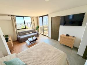 a living room with a bed and a couch at Suite Privada Zona Norte in Miravalle