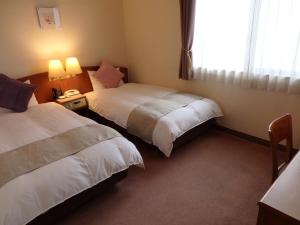 una camera d'albergo con due letti e una finestra di Hotel Hashimotorou a Ishioka