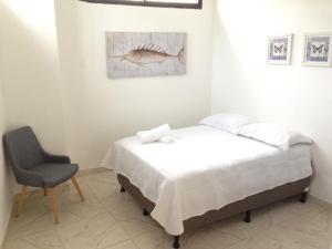 1 dormitorio con 1 cama, 1 silla y 1 pintura en ZOJO MARiNA BAY en San Andrés