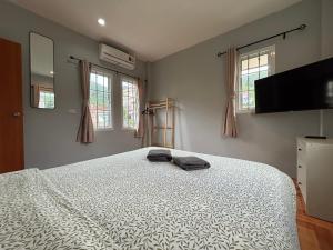 a bedroom with a large bed and two windows at Mango Guest House Choeng Thale in Ban Thalat Choeng Thale