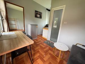 a living room with a table and a refrigerator at Mango Guest House Choeng Thale in Ban Thalat Choeng Thale