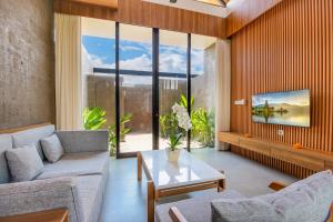 a living room with a couch and a table at Ellavie Villa Ubud in Ubud