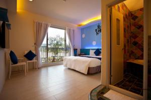 una camera da letto con un letto e un balcone di Millennium Inn II a Kenting