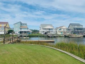 a row of houses next to a body of water at Shore Beats Workin' in Holden Beach
