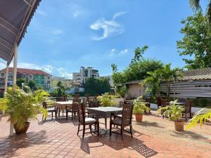 a patio with tables and chairs on a brick patio at Ayothaya Riverside Hotel in Phra Nakhon Si Ayutthaya +34 photos