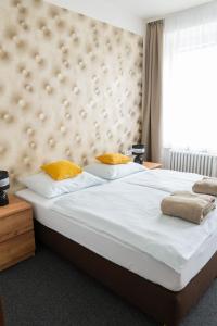 a bedroom with a large white bed with yellow pillows at hotel Dobruška in Dobruška +38 photos