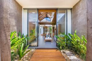 an internal view of a house with glass doors and plants at Ellavie Villa Ubud in Ubud