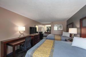 a hotel room with two beds and a desk at Colonial Inn Camden in Camden