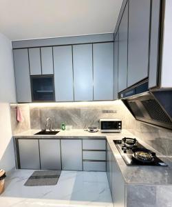 a kitchen with white cabinets and a sink at Noble Cove Batam in Pulau Sembakau Kecil +13 photos